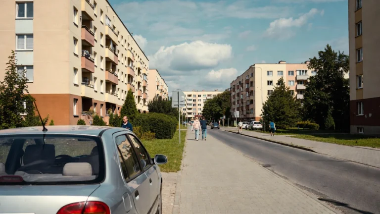 Samochód zaparkowany w Ełku na tle bloków i ulicy w zwykły dzień