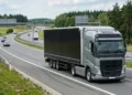 Nowoczesny ciągnik siodłowy z naczepą jadący autostradą w Polsce, ilustrujący zarobki kierowcy zawodowego kat. C+E.